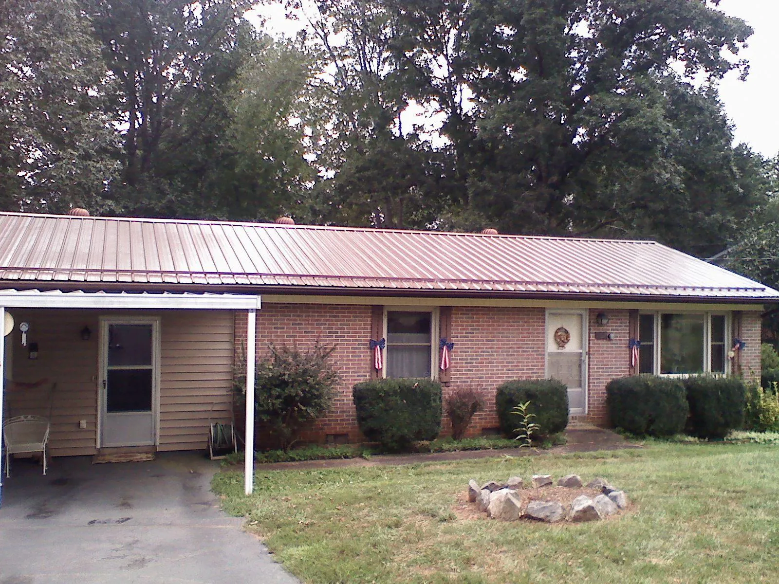 Bronze metal roof and carport on a brick ranch home — Roof Repair work by our crew in Newell